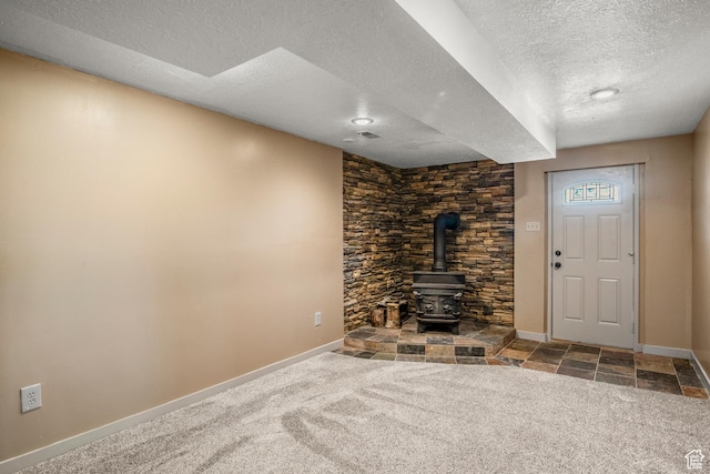 1235 Lakeview Dr, Garden City, UT 84028 - unfurnished living room with a textured ceiling, baseboards, a wood stove, and carpet floors