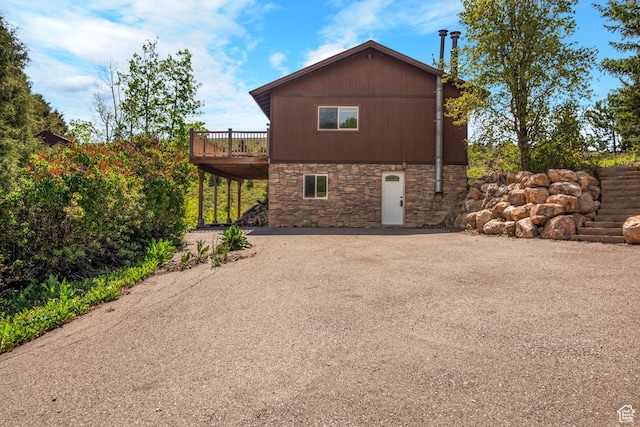 1235 Lakeview Dr, Garden City, UT 84028 - view of side of property featuring stone siding, a deck, and driveway