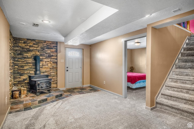 1235 Lakeview Dr, Garden City, UT 84028 - unfurnished living room with a textured ceiling, carpet floors, stairs, baseboards, and a wood stove