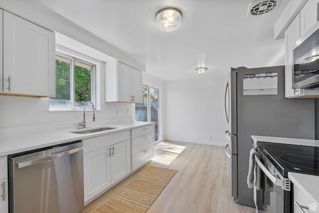 672 Nelson Ave, Tooele, UT 84074 - kitchen featuring appliances with stainless steel finishes, a sink, light wood-type flooring, and light countertops