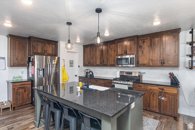 325 W 3170 S, Nibley, UT 84321 - kitchen with appliances with stainless steel finishes, a sink, tasteful backsplash, dark wood finished floors, and dark stone countertops
