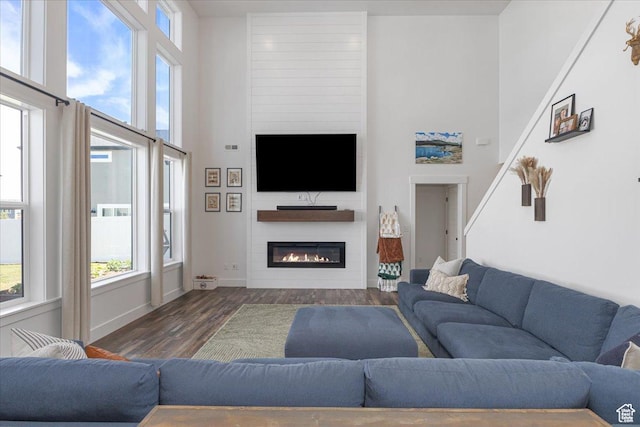 325 W 3170 S, Nibley, UT 84321 - living room featuring wood finished floors, healthy amount of natural light, a large fireplace, baseboards, and a towering ceiling
