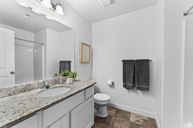 244 E Cordoba Dr, Saratoga Springs, UT 84045 - bathroom featuring baseboards, vanity, stone finish flooring, toilet, and a shower