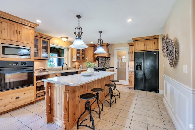 386 W 250 S, Lindon, UT 84042 - kitchen with black appliances, light countertops, a kitchen island, a kitchen breakfast bar, and light tile patterned flooring