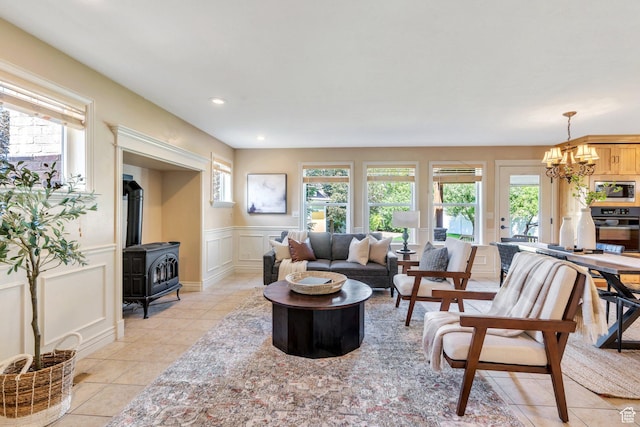 386 W 250 S, Lindon, UT 84042 - living area featuring a wood stove, a chandelier, light tile patterned floors, a decorative wall, and a wainscoted wall