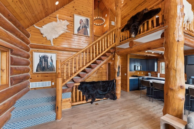 1085 Moose Hollow Rd, Robertson, WY 82944 - stairs with high vaulted ceiling, wooden ceiling, rustic walls, and wood finished floors