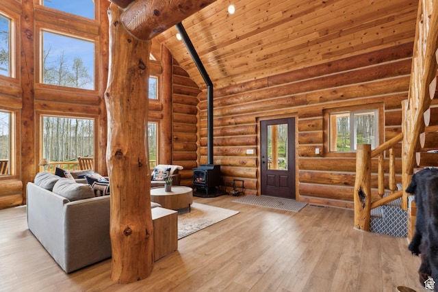 1085 Moose Hollow Rd, Robertson, WY 82944 - living area featuring a wood stove, high vaulted ceiling, hardwood / wood-style flooring, wooden ceiling, and log walls