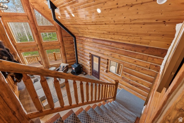 1085 Moose Hollow Rd, Robertson, WY 82944 - staircase with log walls, a wood stove, wooden ceiling, and healthy amount of natural light