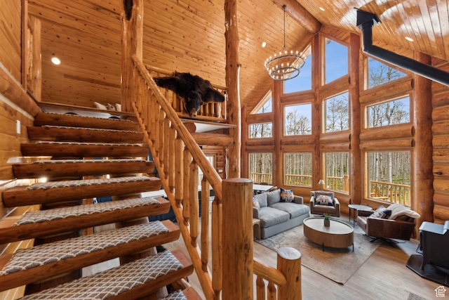 1085 Moose Hollow Rd, Robertson, WY 82944 - living room with high vaulted ceiling, wooden ceiling with exposed beams, stairs, wood finished floors, and log walls