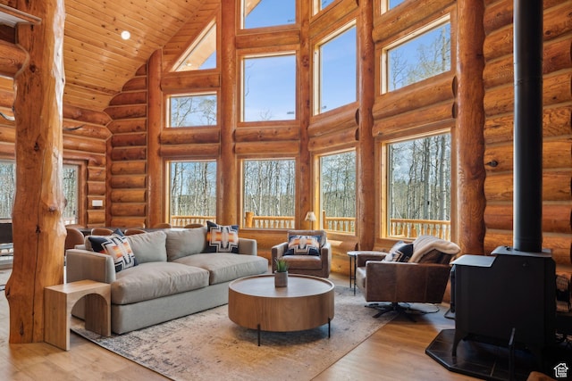 1085 Moose Hollow Rd, Robertson, WY 82944 - living room featuring high vaulted ceiling, a wood stove, plenty of natural light, log walls, and wood finished floors