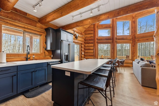 1085 Moose Hollow Rd, Robertson, WY 82944 - kitchen with rail lighting, a sink, dishwasher, light countertops, and log walls