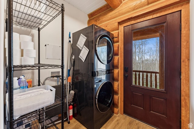 1085 Moose Hollow Rd, Robertson, WY 82944 - laundry room featuring stacked washing machine and dryer, wood finished floors, and rustic walls