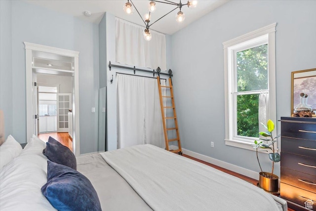 479 N Main St, Farmington, UT 84025 - bedroom with multiple windows, a barn door, baseboards, and wood finished floors