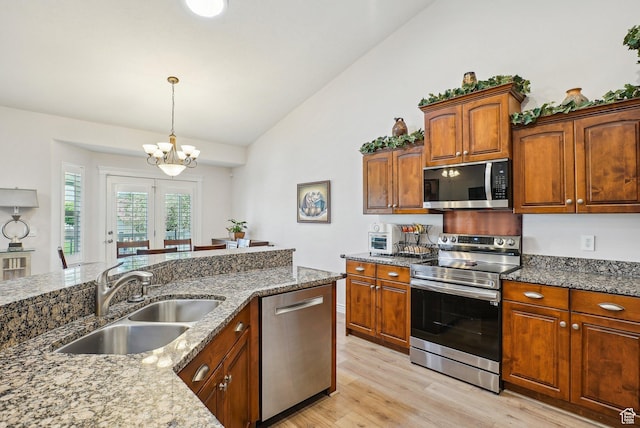 9451 S Peaceful View Way S, Jordan, UT 84095 - kitchen with appliances with stainless steel finishes, a sink, light wood finished floors, stone counters, and high vaulted ceiling
