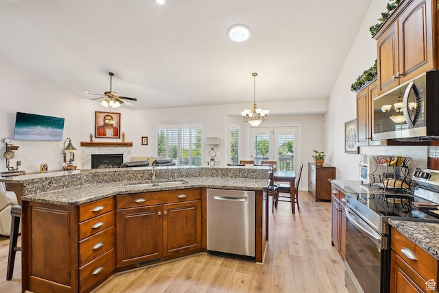 9451 S Peaceful View Way S, Jordan, UT 84095 - kitchen featuring stainless steel appliances, a sink, a fireplace, light wood finished floors, and ceiling fan