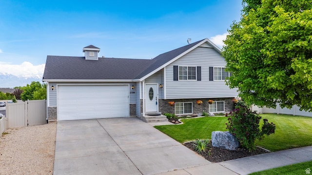 2384 N Nectar Way E, Saratoga Springs, UT 84045 - split level home featuring stone siding, an attached garage, driveway, and a gate