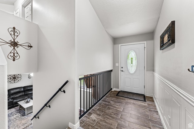 2384 N Nectar Way E, Saratoga Springs, UT 84045 - foyer entrance with wood finished floors, a wainscoted wall, a textured ceiling, and a decorative wall