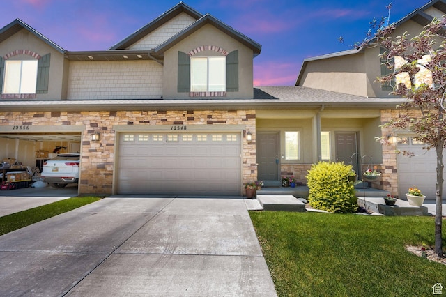 12548 S Alice Ct W, Riverton, UT 84065 - view of front of house with stone siding, concrete driveway, an attached garage, a front yard, and stucco siding