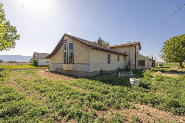 10205 W 10400 N, Tremonton, UT 84337 - rear view of house featuring a chimney, a mountain view, and brick siding
