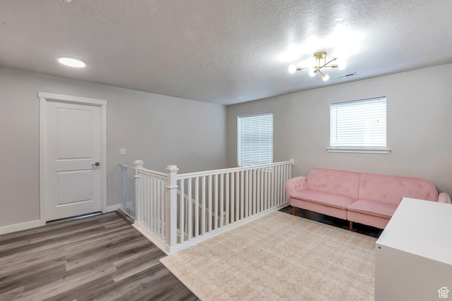 945 W Mckenna Rd, Bluffdale, UT 84065 - living area featuring wood finished floors, a textured ceiling, baseboards, an upstairs landing, and a chandelier