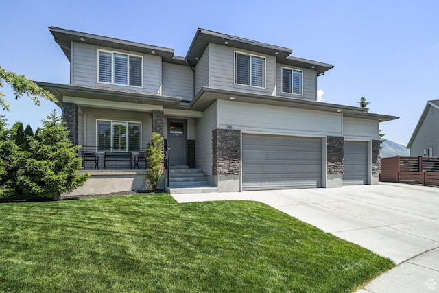 149 E 230 N, Vineyard, UT 84059 - view of front of home featuring stone siding, driveway, an attached garage, and covered porch