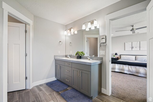 149 E 230 N, Vineyard, UT 84059 - ensuite bathroom featuring double vanity, baseboards, a textured ceiling, and ceiling fan
