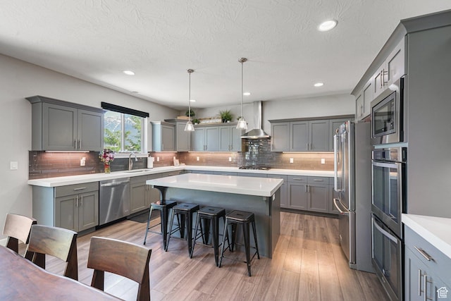 149 E 230 N, Vineyard, UT 84059 - kitchen featuring stainless steel appliances, a sink, gray cabinets, wall chimney range hood, and a breakfast bar