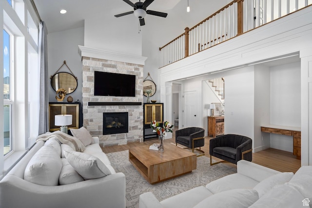648 W 400 N, Mapleton, UT 84664 - living room featuring wood finished floors, ceiling fan, healthy amount of natural light, a fireplace, and a towering ceiling