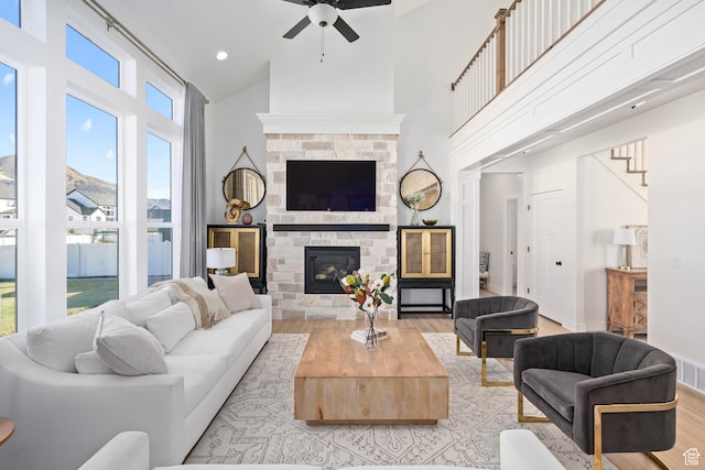 648 W 400 N, Mapleton, UT 84664 - living area with high vaulted ceiling, light wood-type flooring, ceiling fan, a glass covered fireplace, and stairs