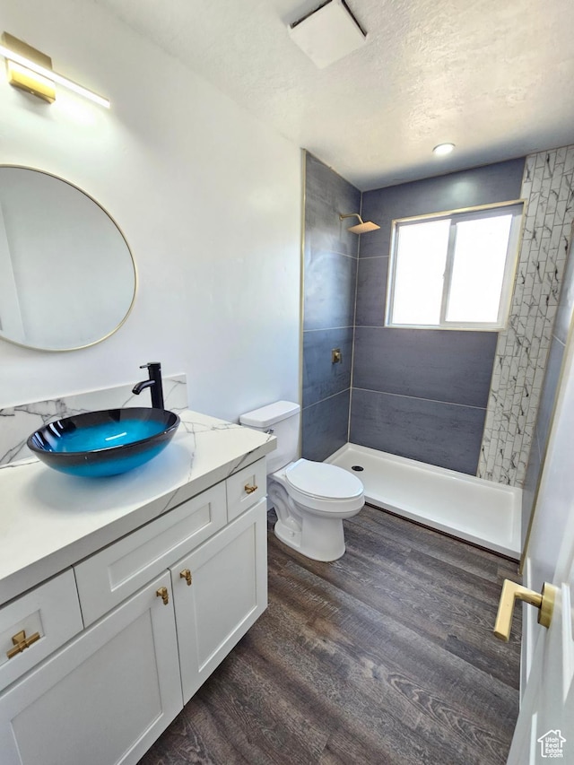 8181 W Danbury Dr, Magna, UT 84044 - bathroom with vanity, a shower stall, toilet, wood finished floors, and a textured ceiling