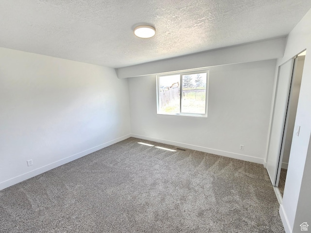 8181 W Danbury Dr, Magna, UT 84044 - unfurnished bedroom with carpet, a textured ceiling, and baseboards