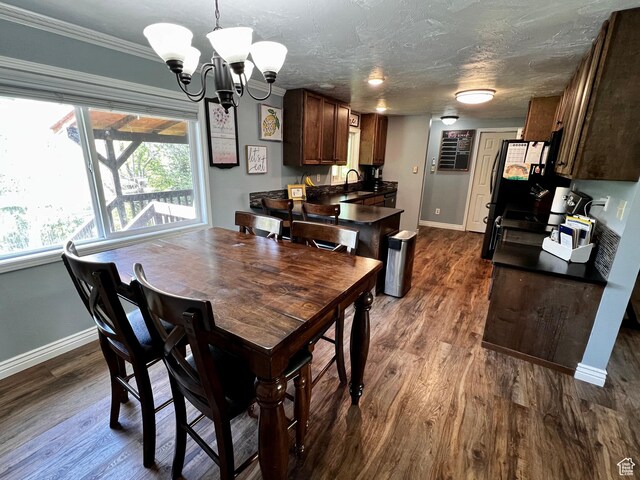 130 Cascade Quey St, Soda Springs, ID 83276 - dining area with baseboards, a chandelier, dark wood-type flooring, and crown molding