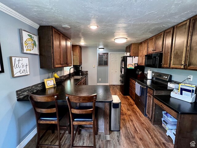130 Cascade Quey St, Soda Springs, ID 83276 - kitchen with black appliances, a sink, dark countertops, a peninsula, and dark wood-type flooring