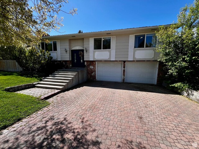 130 Cascade Quey St, Soda Springs, ID 83276 - split foyer home featuring an attached garage, decorative driveway, and stone siding