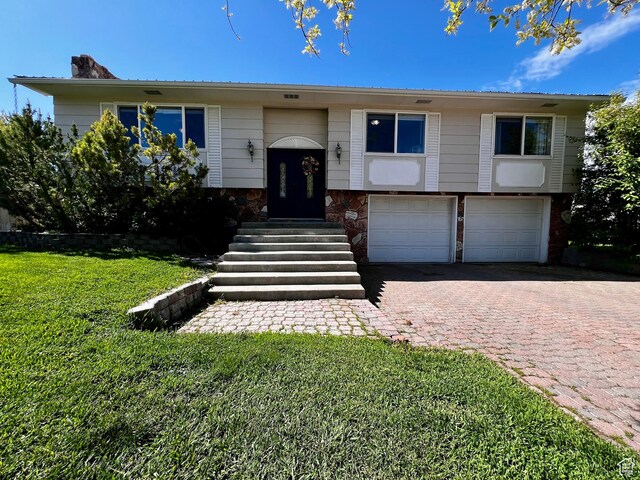 130 Cascade Quey St, Soda Springs, ID 83276 - raised ranch featuring a garage, a front lawn, decorative driveway, and a chimney