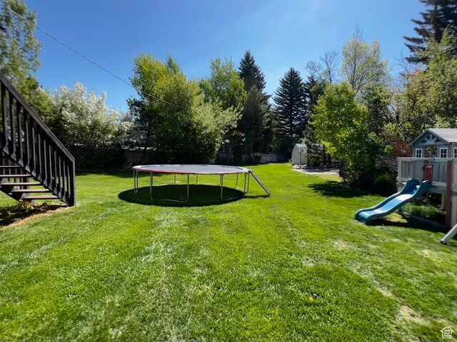130 Cascade Quey St, Soda Springs, ID 83276 - view of grassy yard featuring a trampoline, a playground, and stairs