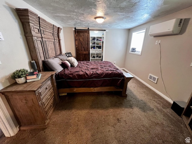 130 Cascade Quey St, Soda Springs, ID 83276 - bedroom with a wall mounted air conditioner, a barn door, a textured ceiling, dark carpet, and baseboards