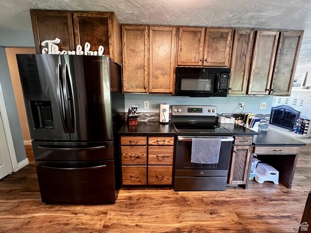 130 Cascade Quey St, Soda Springs, ID 83276 - kitchen featuring black appliances, dark countertops, brown cabinets, and wood finished floors