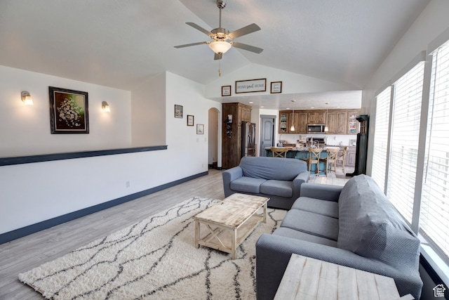 343 W Deer Creek Trl, Salem, UT 84653 - living area with vaulted ceiling, arched walkways, a ceiling fan, light wood-type flooring, and baseboards