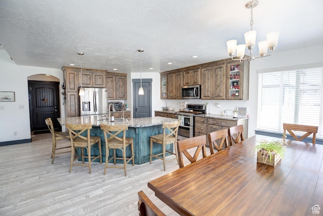 343 W Deer Creek Trl, Salem, UT 84653 - dining area with arched walkways, a textured ceiling, light wood-style floors, a chandelier, and recessed lighting