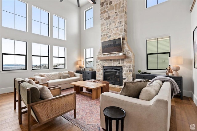 3651 N 200 E, North Ogden, UT 84414 - living room with a stone fireplace, a towering ceiling, baseboards, and wood-type flooring