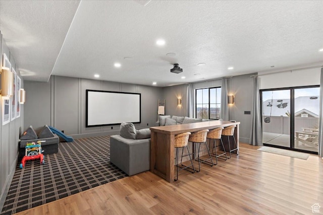 3651 N 200 E, North Ogden, UT 84414 - home theater featuring light wood-type flooring, a textured ceiling, recessed lighting, and a decorative wall