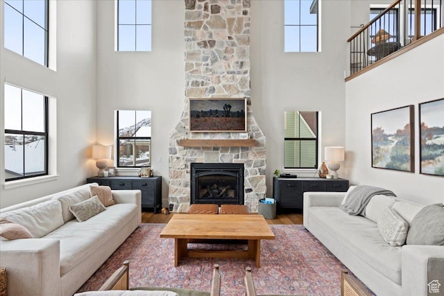 3651 N 200 E, North Ogden, UT 84414 - living room featuring a stone fireplace, a high ceiling, wood finished floors, and plenty of natural light