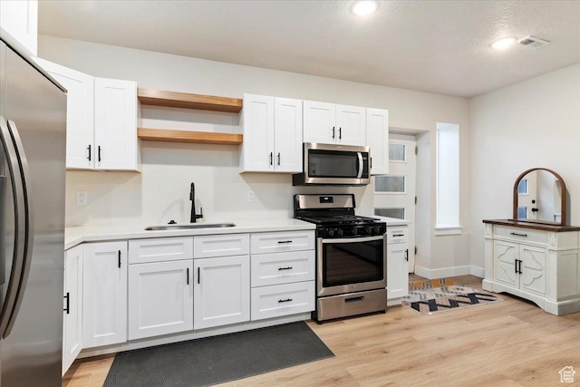 325 N 1200 E, American Fork, UT 84003 - kitchen featuring appliances with stainless steel finishes, a sink, white cabinets, light wood finished floors, and light countertops