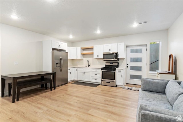 325 N 1200 E, American Fork, UT 84003 - kitchen with appliances with stainless steel finishes, open floor plan, open shelves, light wood-type flooring, and light countertops