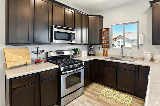 5186 W Hedgerose Dr S, Herriman, UT 84096 - kitchen featuring stainless steel appliances, a sink, dark brown cabinetry, and light wood finished floors