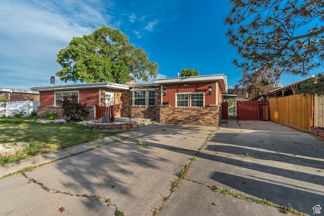 3067 W Lemay Ave S, West Valley City, UT 84119 - view of front of house with brick siding, a gate, and driveway