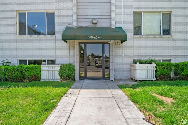 1860 W 500 N Unit 7, Salt Lake City, UT 84116 - doorway to property with brick siding and a lawn