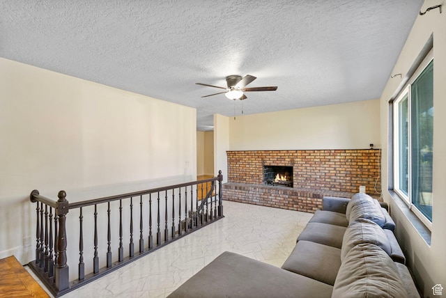 4589 S Trojan Dr, West Valley City, UT 84120 - living area featuring a ceiling fan, a fireplace, marble finish flooring, and a textured ceiling