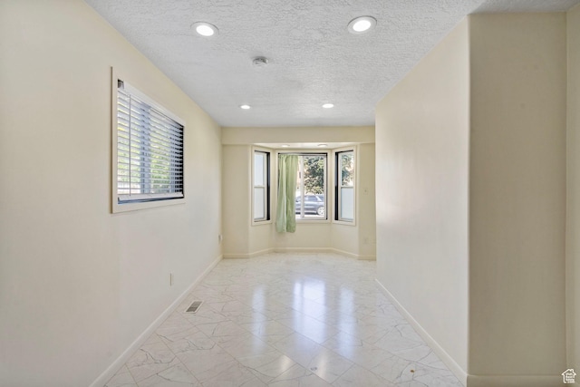 4589 S Trojan Dr, West Valley City, UT 84120 - spare room with a textured ceiling, plenty of natural light, light marble finish floors, baseboards, and recessed lighting
